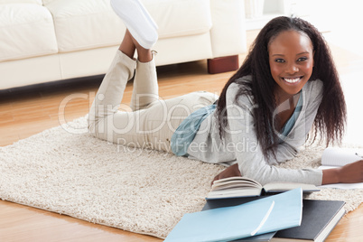 Woman lying on the floor doing her homework