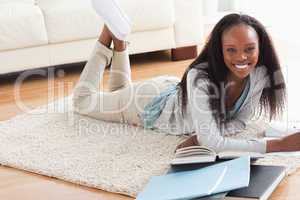 Woman lying on the floor doing her homework