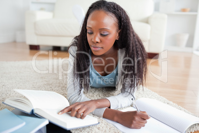 Woman lying on the floor doing homework