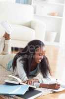 Woman lying on the floor taking notes