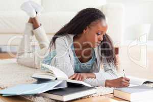 Woman lying on carpet working on book review