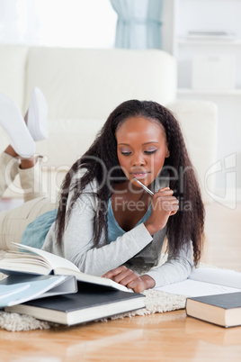 Female student lying on floor doing homework