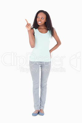 Woman pointing at something next to her on a white background