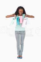 Woman having a look in her shopping bags on white background