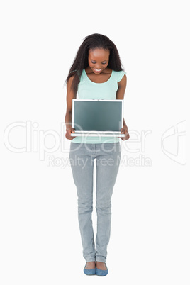 Woman showing her laptop screen on white background