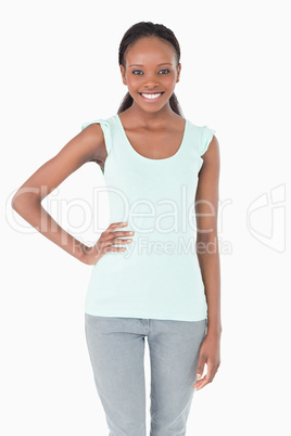 Close up of young woman with one arm akimbo on white background