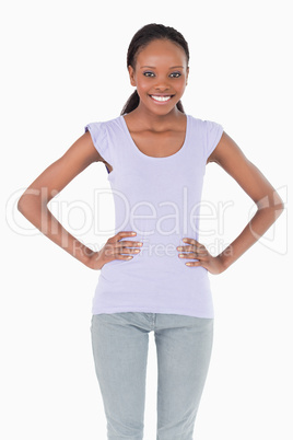 Close up of young woman with arms akimbo on white background