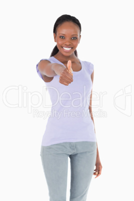 Close up of thumb up being given by woman on white background