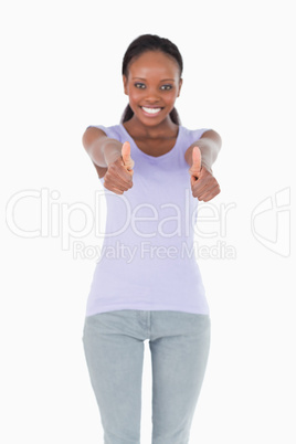 Close up of thumbs up being given by woman on white background
