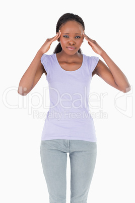 Close up of woman with hands at her temples on white background