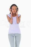Close up of woman listening to music on white background