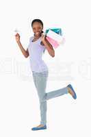 Woman with shopping and credit card on white background