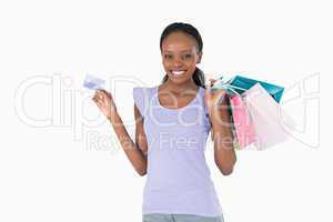 Happy woman with her shopping and credit card on white backgroun