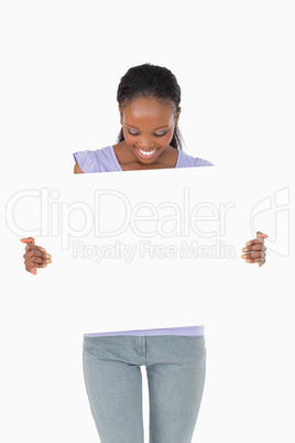 Close up of woman looking at placeholder in her hands on white b