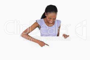 Woman looking at what she is pointing at on white background