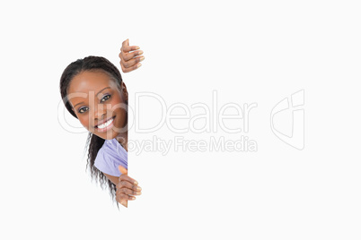 Woman taking a look around the corner on white background