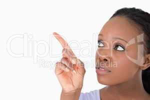 Close up of woman pointing at something next to her on a white b