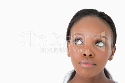 Close up of woman's face looking upwards diagonally on white bac