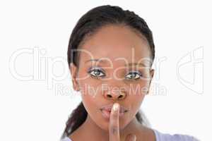 Close up of woman demanding silence on white background