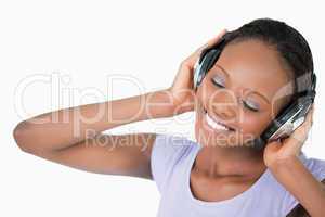 Close up of woman listening to music against a white background