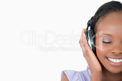 Close up of young woman enjoying music on white background