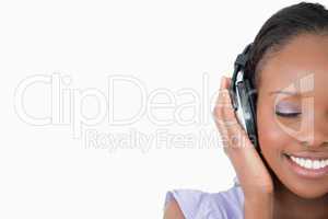 Close up of young woman enjoying music on white background