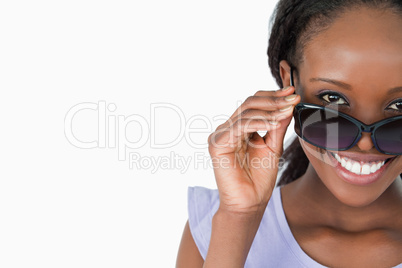 Close up of woman looking over her sunglasses on white backgroun