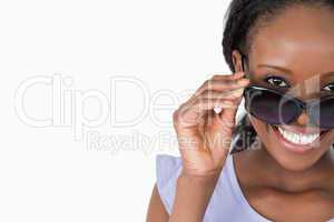 Close up of woman looking over her sunglasses on white backgroun