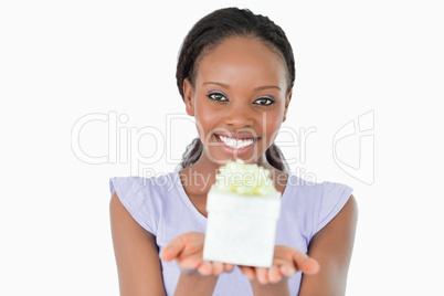 Close up of woman holding a present against a white background