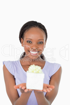 Close up of smiling woman holding a present against a white back