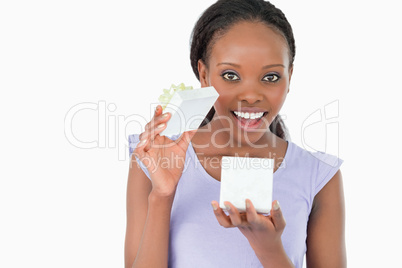 Close up of woman opening a present against a white background