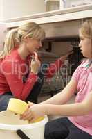 Daughter Helping Mother To Mop Up Leaking Sink