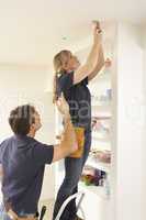 Electrician Teaching Apprentice To Install Light Fitting In Home