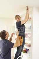 Electrician Teaching Apprentice To Install Light Fitting In Home