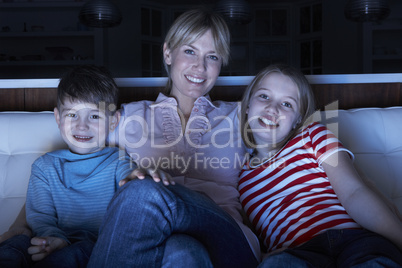 Mother And Children Watching Programme On TV Sitting On Sofa Tog