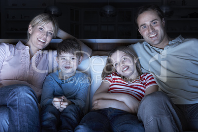 Family Watching TV On Sofa Together