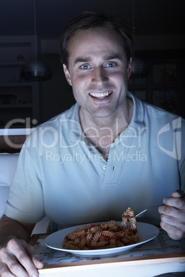 Man Enjoying Meal Whilst Watching TV