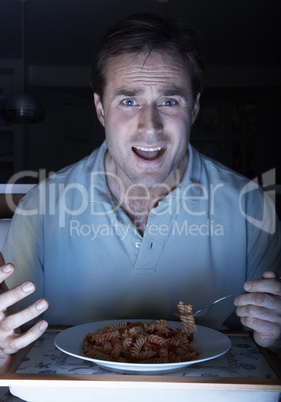 Man Enjoying Meal Whilst Watching TV