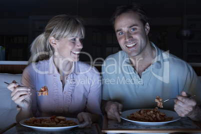 Couple Enjoying Meal Whilst Watching TV