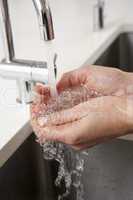 Close Up Of Woman Washing Hands At Kitchen Sink