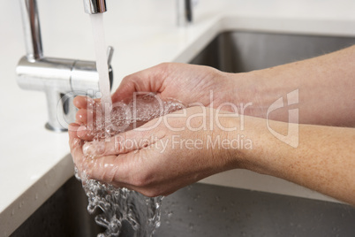 Close Up Of Woman Washing Hands At Kitchen Sink