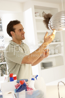 Man Cleaning Light Fitting With Feather Duster