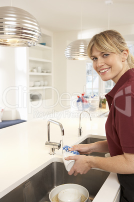 Cleaner Working In Domestic Kitchen