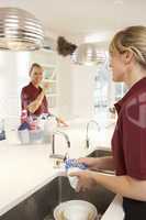 Team Of Commercial Cleaners Working In Domestic Kitchen