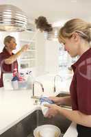 Team Of Commercial Cleaners Working In Domestic Kitchen