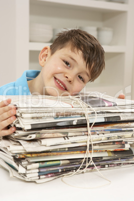 Young Boy Recyling Newspapers At Home