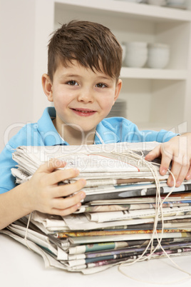 Young Boy Recyling Newspapers At Home