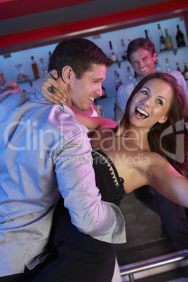 Couple Having Fun In Busy Bar