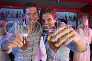 Two Young Men Having Fun In Busy Bar