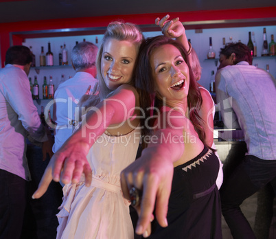 Two Young Women Having Fun In Busy Bar